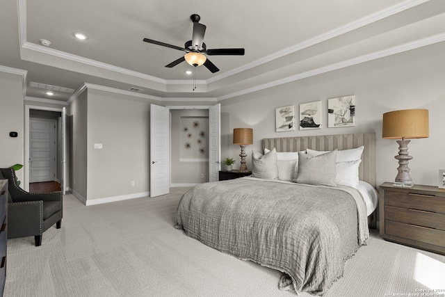 carpeted bedroom with ceiling fan, ornamental molding, and a tray ceiling