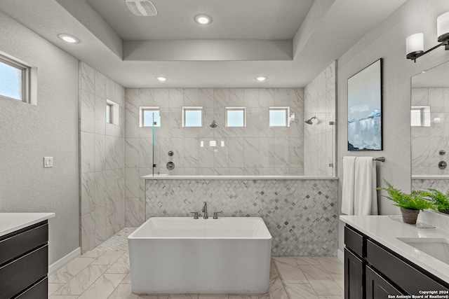 bathroom featuring vanity, plus walk in shower, and a raised ceiling