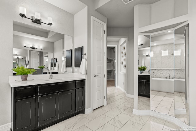 bathroom featuring vanity, a textured ceiling, and a bath