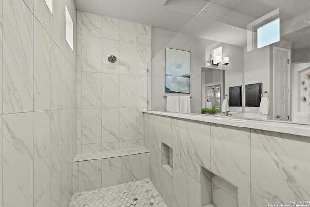 bathroom featuring a tile shower and vanity