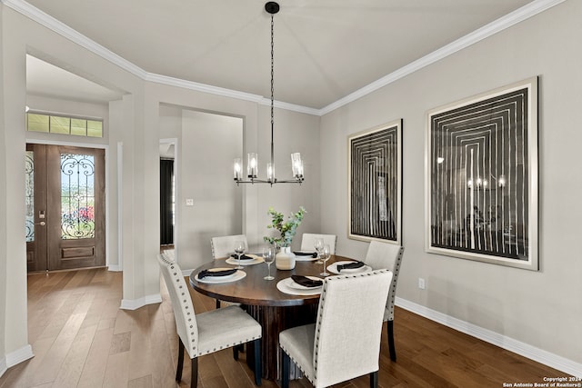 dining room with an inviting chandelier, crown molding, and hardwood / wood-style floors