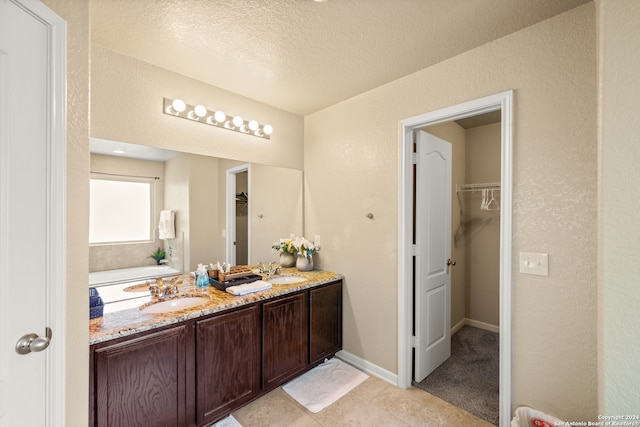 bathroom with vanity, a textured ceiling, and tile patterned floors