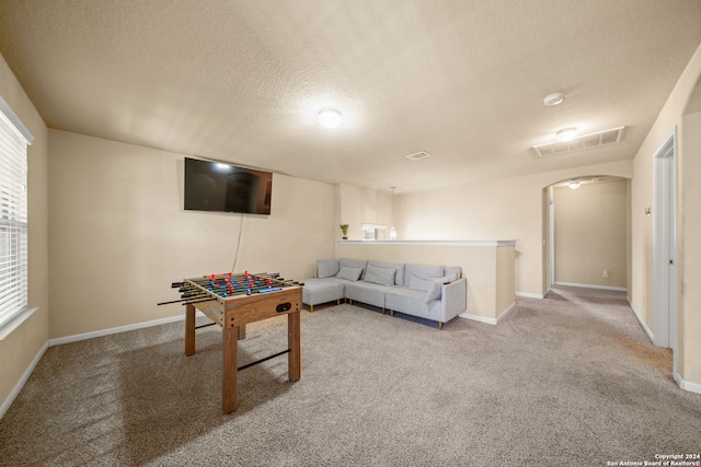 game room with light carpet and a textured ceiling