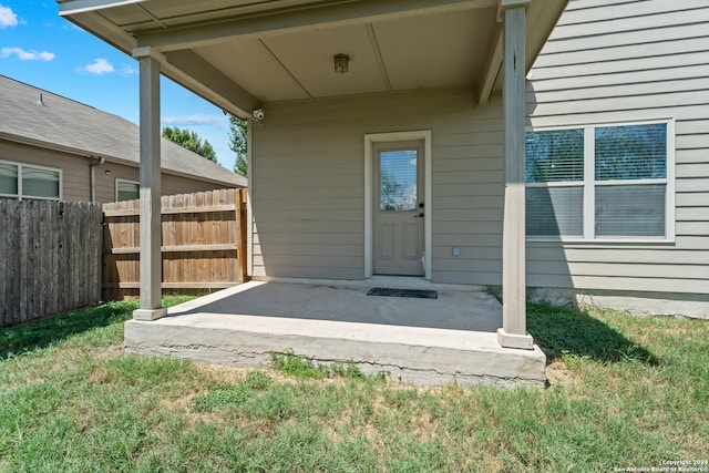 doorway to property with a patio and a lawn