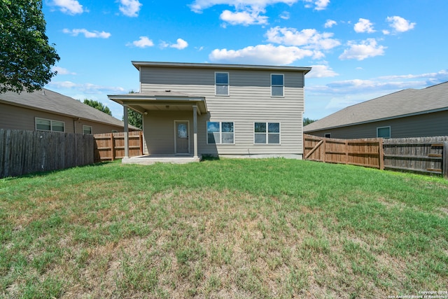 rear view of property featuring a yard and a patio area