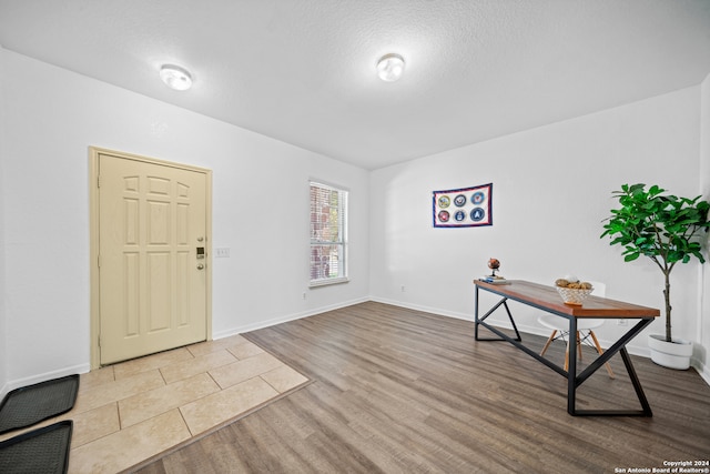 foyer with light hardwood / wood-style flooring and a textured ceiling