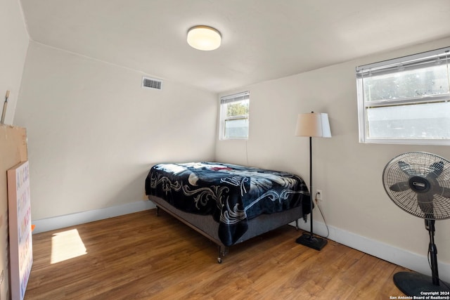 bedroom featuring visible vents, wood finished floors, and baseboards