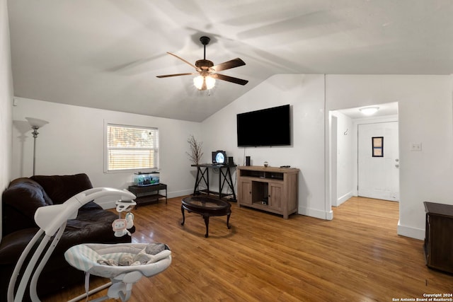 living room with baseboards, a ceiling fan, light wood-style flooring, and vaulted ceiling