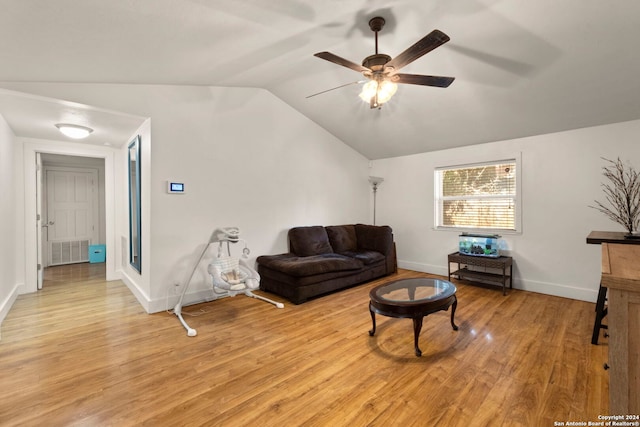 living area with baseboards, ceiling fan, light wood-style floors, and vaulted ceiling