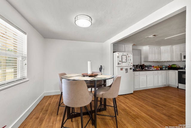 dining room with baseboards and light wood-type flooring