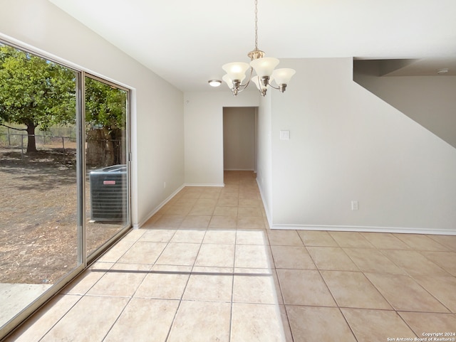 empty room featuring light tile patterned flooring and an inviting chandelier