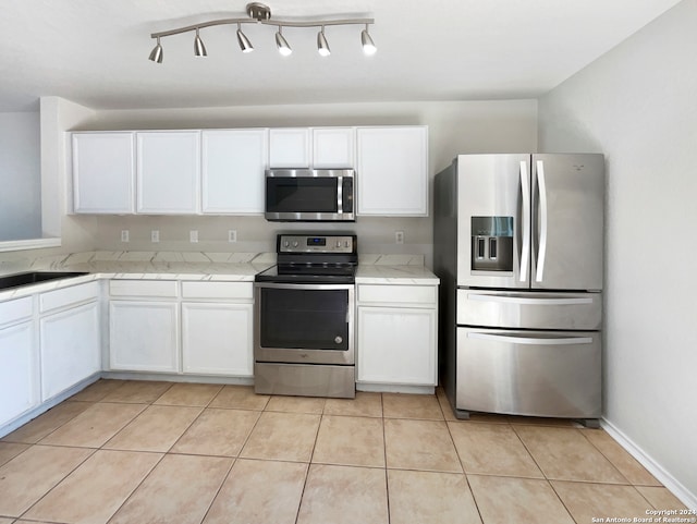 kitchen featuring appliances with stainless steel finishes, white cabinetry, and light tile patterned floors