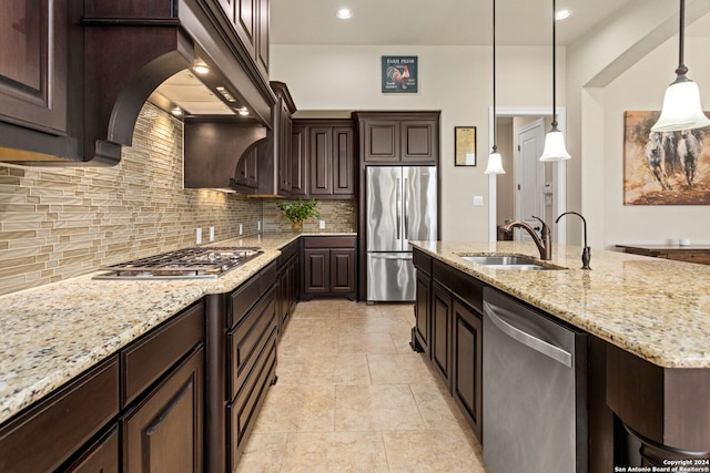 kitchen featuring hanging light fixtures, dark brown cabinets, stainless steel appliances, light stone countertops, and tasteful backsplash