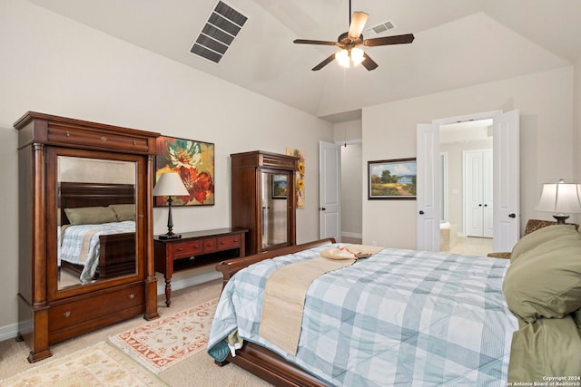 bedroom featuring lofted ceiling, ensuite bathroom, light colored carpet, and ceiling fan