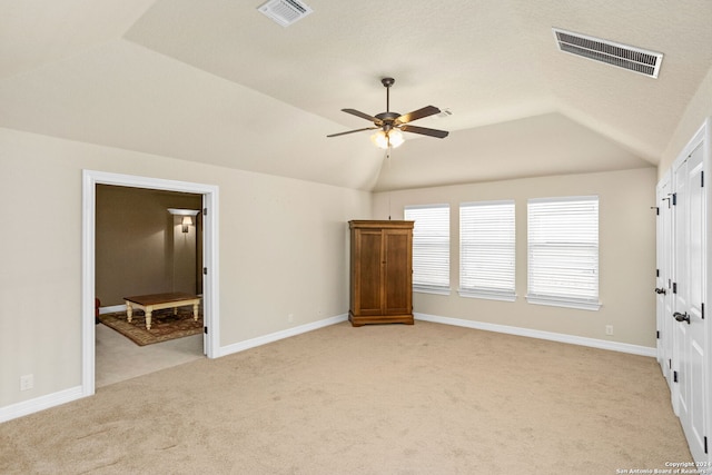 unfurnished bedroom featuring lofted ceiling, light colored carpet, and ceiling fan