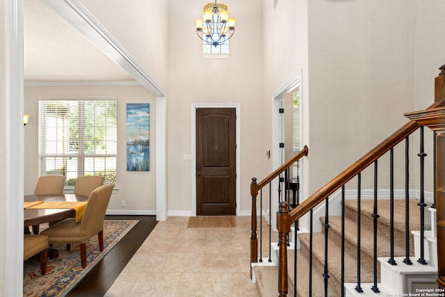 entrance foyer featuring an inviting chandelier, ornamental molding, and light hardwood / wood-style floors