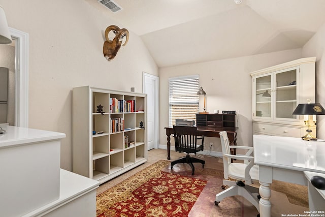 carpeted home office with vaulted ceiling