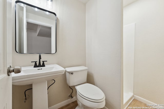 bathroom featuring wood-type flooring and toilet