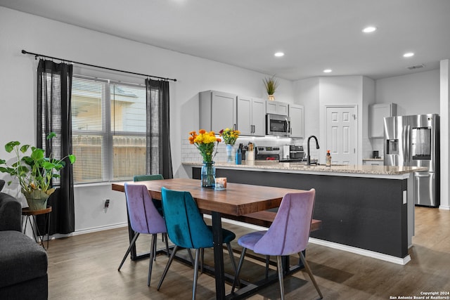 dining area with hardwood / wood-style flooring and sink