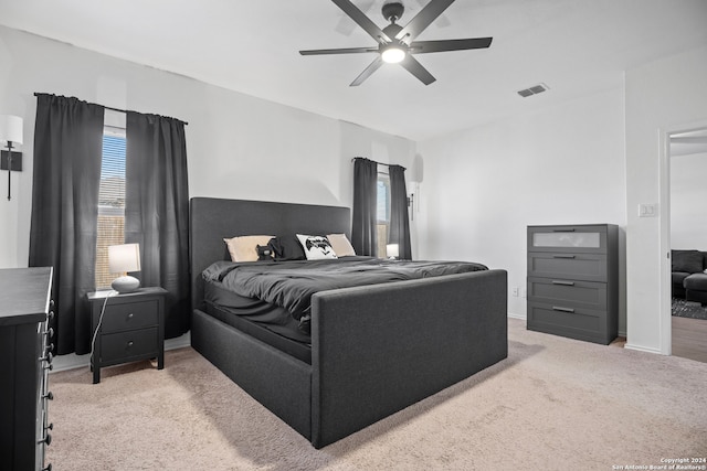 bedroom featuring light carpet, multiple windows, and ceiling fan