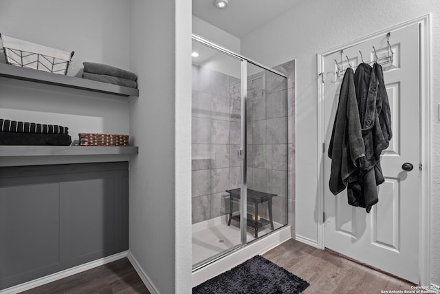 bathroom with hardwood / wood-style floors and an enclosed shower