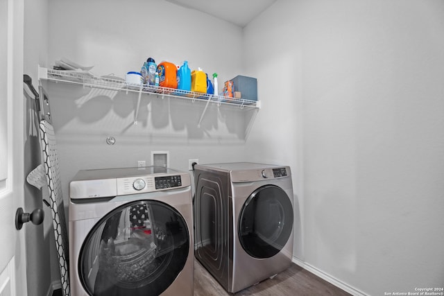 clothes washing area featuring washer and clothes dryer and hardwood / wood-style flooring