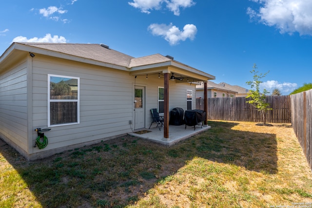 back of property with a patio, ceiling fan, and a lawn