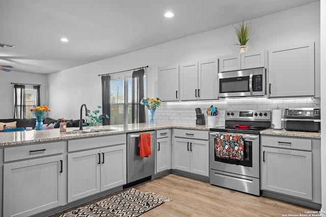 kitchen featuring light hardwood / wood-style flooring, a healthy amount of sunlight, appliances with stainless steel finishes, and sink