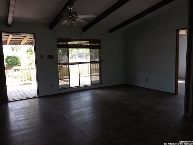 empty room featuring ceiling fan, a wealth of natural light, and vaulted ceiling with beams