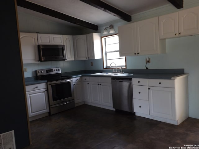 kitchen featuring white cabinetry, stainless steel appliances, sink, and lofted ceiling with beams