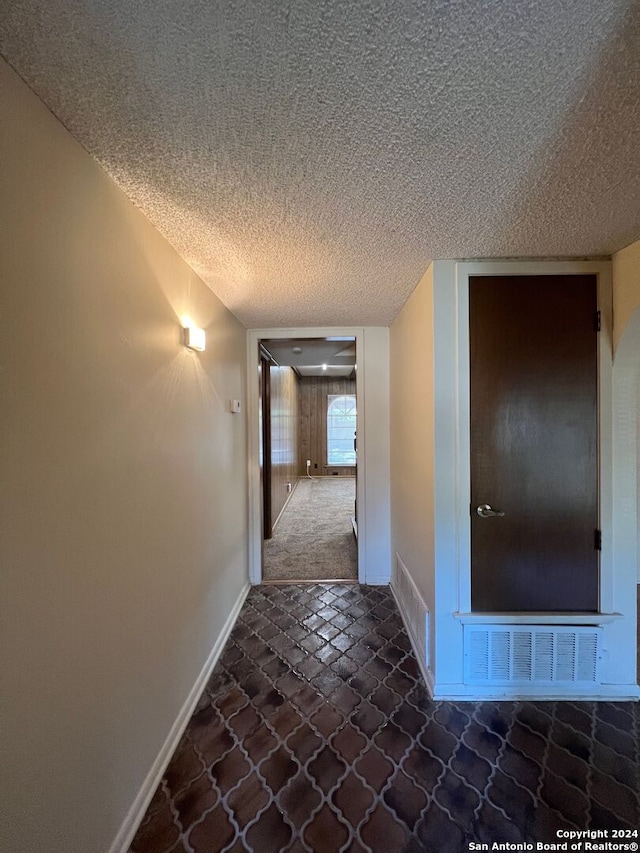 hall featuring a textured ceiling