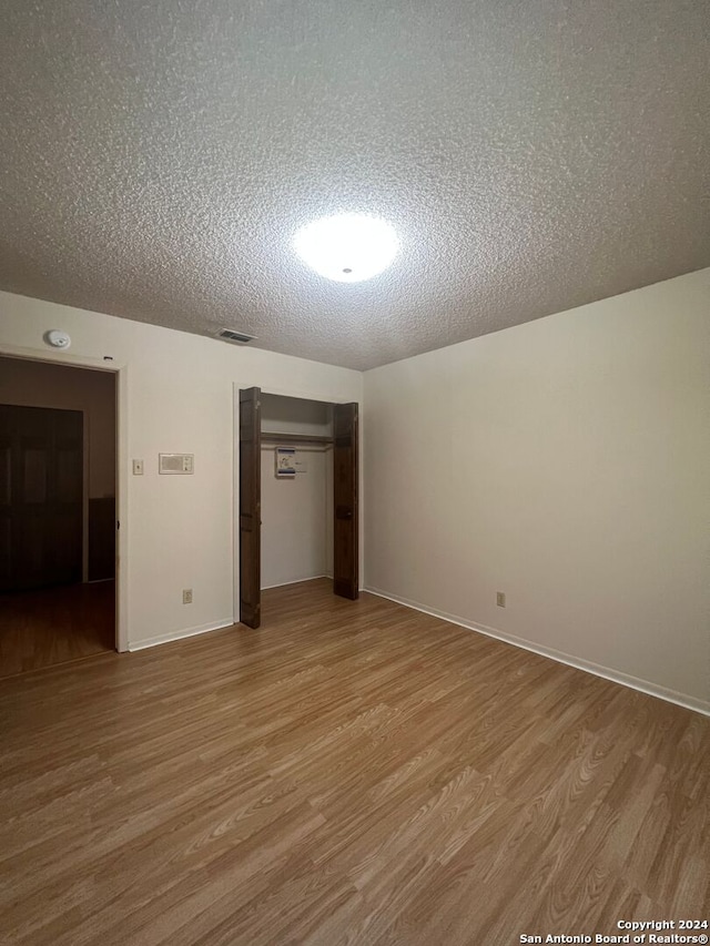 unfurnished bedroom featuring light hardwood / wood-style flooring and a textured ceiling