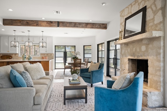 living room featuring beamed ceiling and a fireplace