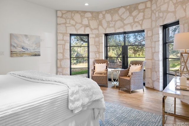 bedroom featuring access to exterior and wood-type flooring