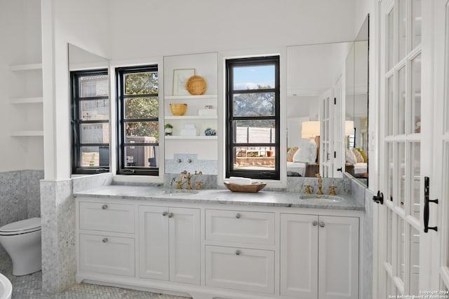 bar featuring a healthy amount of sunlight, sink, and white cabinets