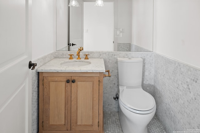 bathroom with vanity, tile walls, toilet, and tile patterned floors