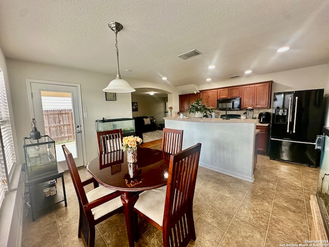 dining area featuring a textured ceiling and light tile patterned floors