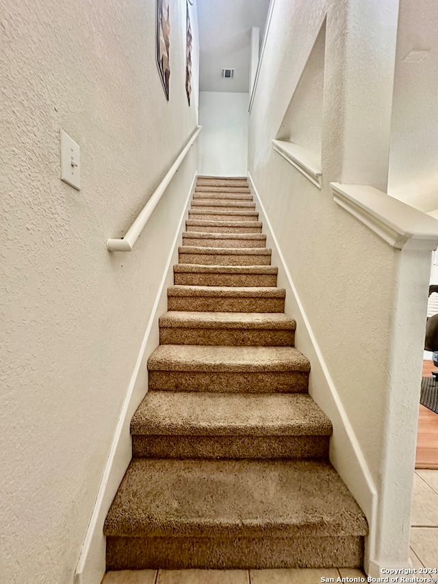 stairway with tile patterned flooring