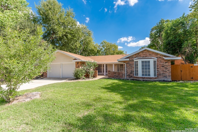 ranch-style house featuring a front lawn and a garage