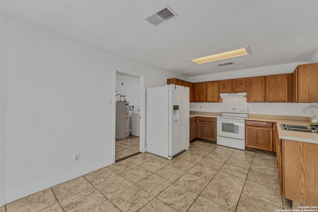 kitchen with water heater, sink, and white appliances