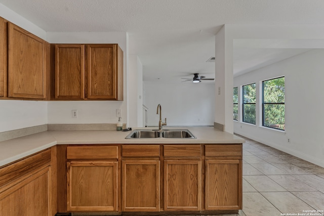 kitchen featuring a textured ceiling, sink, ceiling fan, and light tile patterned flooring