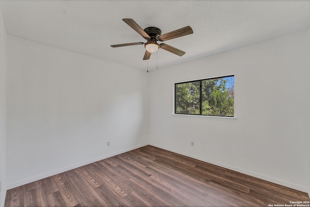 empty room featuring dark hardwood / wood-style flooring, a textured ceiling, and ceiling fan