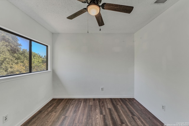 spare room featuring dark wood-type flooring, a textured ceiling, and ceiling fan