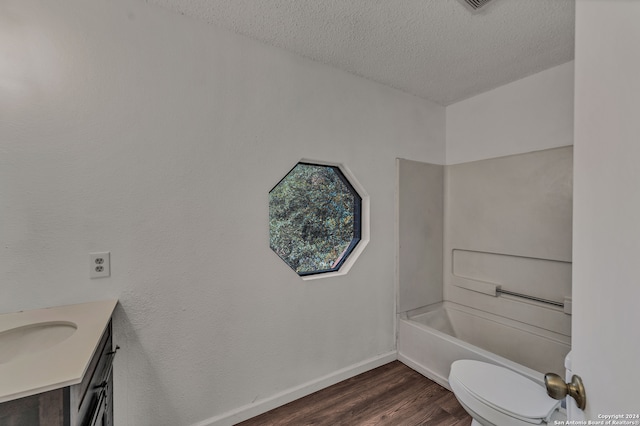 full bathroom with vanity, a textured ceiling, shower / tub combination, hardwood / wood-style floors, and toilet