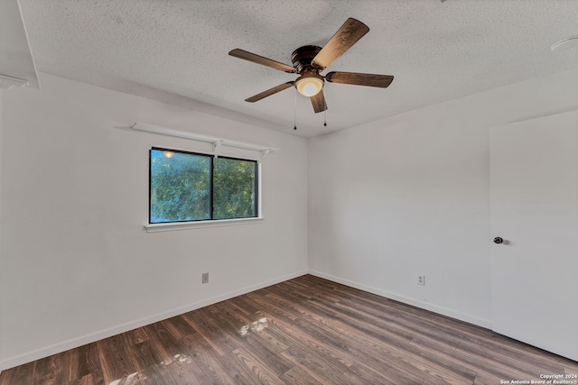 empty room with a textured ceiling, ceiling fan, and dark hardwood / wood-style floors