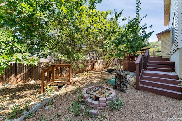 view of yard featuring a wooden deck and a fire pit