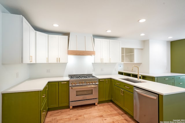 kitchen with white cabinets, stainless steel appliances, sink, light hardwood / wood-style floors, and green cabinets