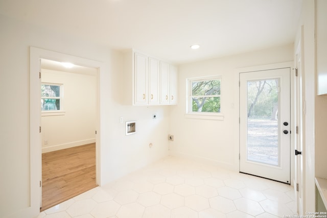 laundry area featuring light hardwood / wood-style floors, hookup for an electric dryer, cabinets, and plenty of natural light