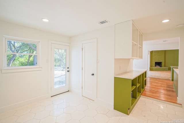 interior space featuring light hardwood / wood-style floors, green cabinetry, and a fireplace