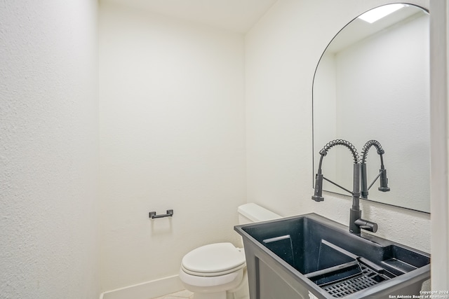 bathroom with toilet, vanity, and tile patterned flooring